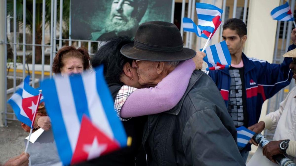 Un grupo de personas se saluda frente a un retrato del fallecido gobernante cubano Fidel Castro el 8 de enero, en La Habana, Cuba.