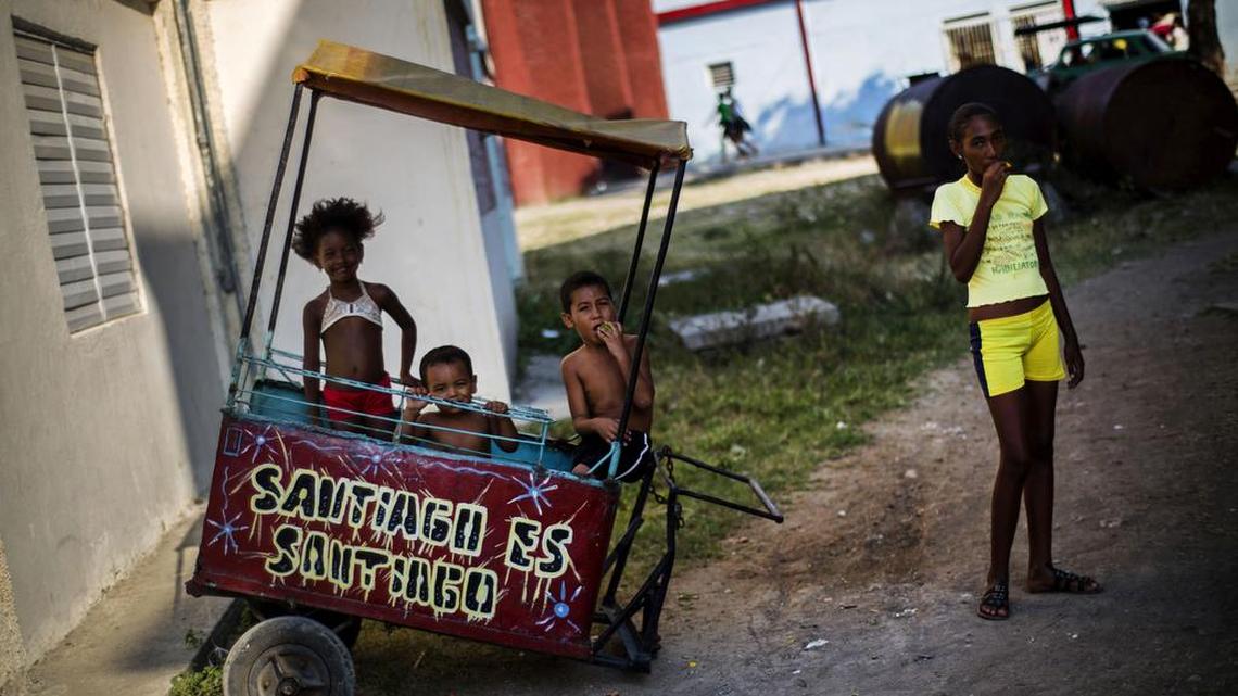 Varios niños juegan en una calle de Santiago de Cuba, junto a un carrito de venta de comida, en esta foto de marzo del 2015.