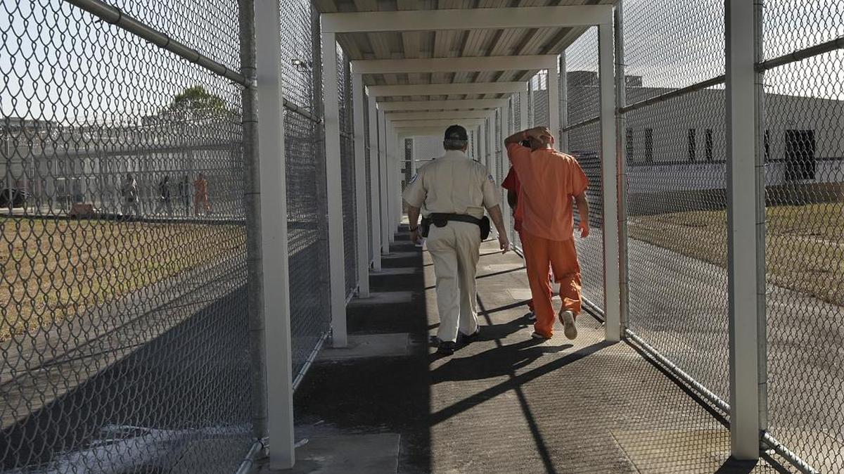 Inmigrantes detenidos son escoltados en uno de los pasillos del Centro de Detención de Krome en Miami.