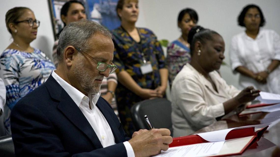 El abogado Scott Gilbert, presidente de la empresa estadounidense Coabana Trading LLC e Isabel O'Reilly, directora de CubaExport, firman un acuerdo que permite la exportación de carbón cubano a los Estados Unidos en La Habana, Cuba, el jueves 5 de enero de 2017.