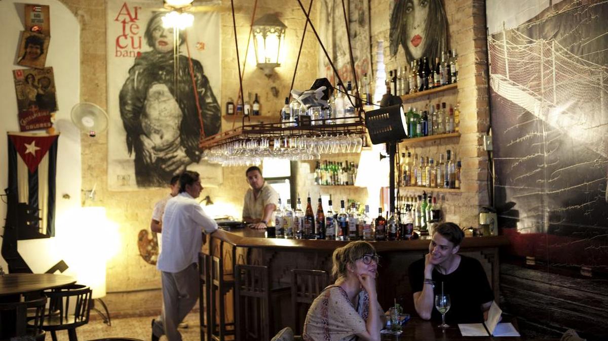 
Turistas toman una copa en el Bar Madrigal, en La Habana. El arribo de visitantes estadounidenses a la isla se incrementó en un 54% desde el deshielo.
