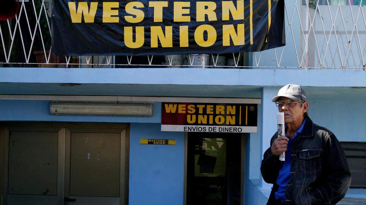 ARCHIVO - En esta foto de archivo del 28 de diciembre de 2010, Claudio Calderón espera recibir dinero enviado por sus familiares en EE.UU., de una agencia de Western Union en La Habana, Cuba.