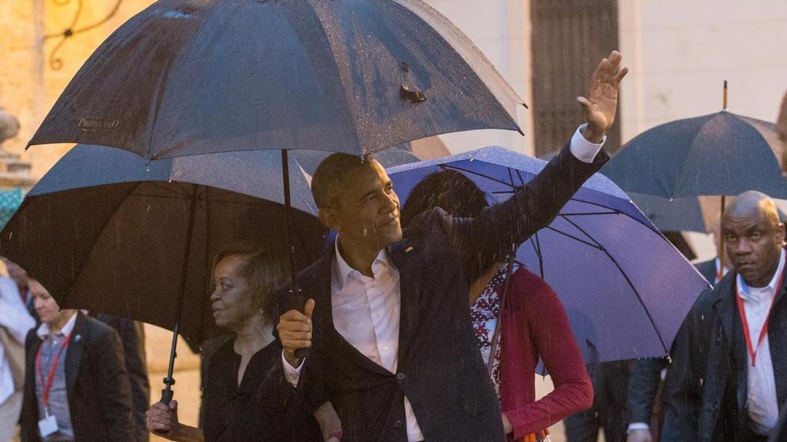 El presidente de Estados Unidos Barack Obama (frente) saluda su llegada hoy, domingo 20 de marzo de 2016, a la Catedral de La Habana (Cuba). Obama junto a su esposa Michelle y sus hijas Sasha y Malia, visitaron La Habana Vieja, el centro histórico de la capital de Cuba, un paseo que tuvieron que realizar protegidos por paraguas debido a la lluvia que les ha recibido en la ciudad.
