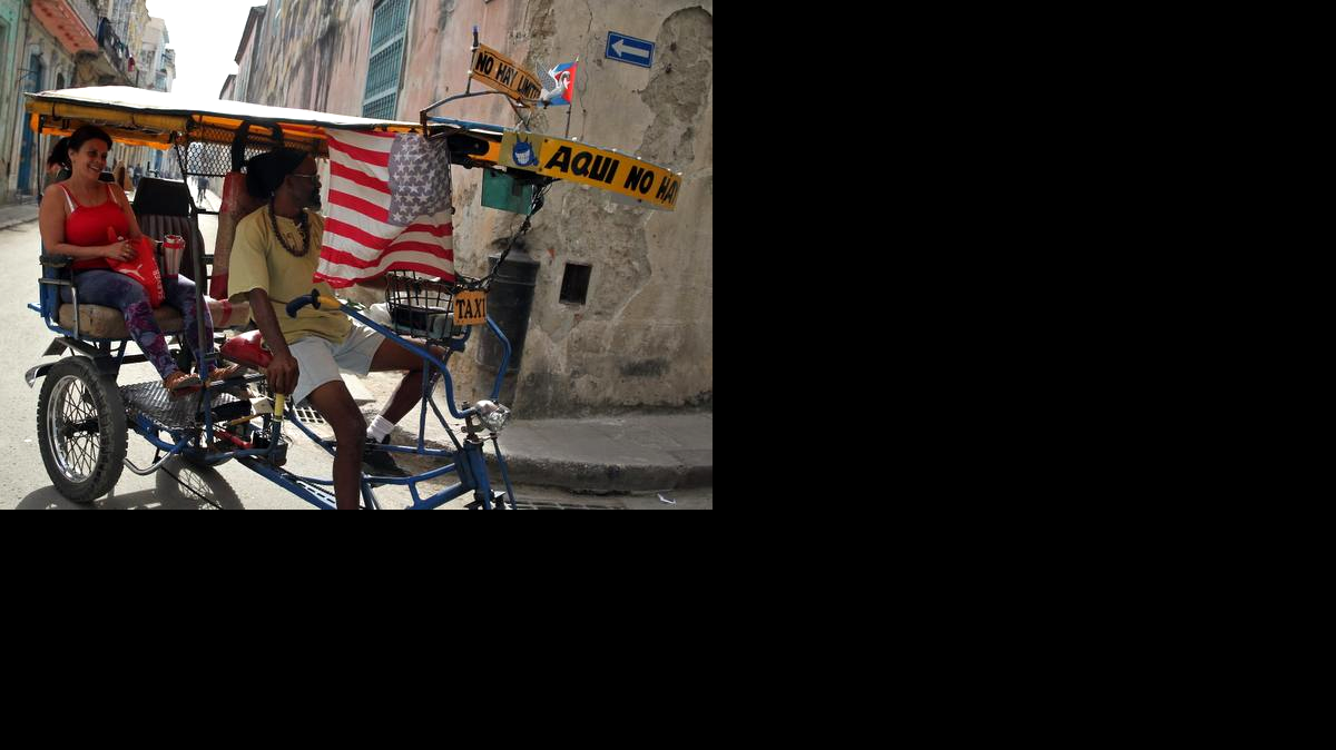 
Un bicitaxi adornado con una bandera de Estados Unidos circula por una calle de La Habana (Cuba), el martes 31 de marzo de 2015. 

