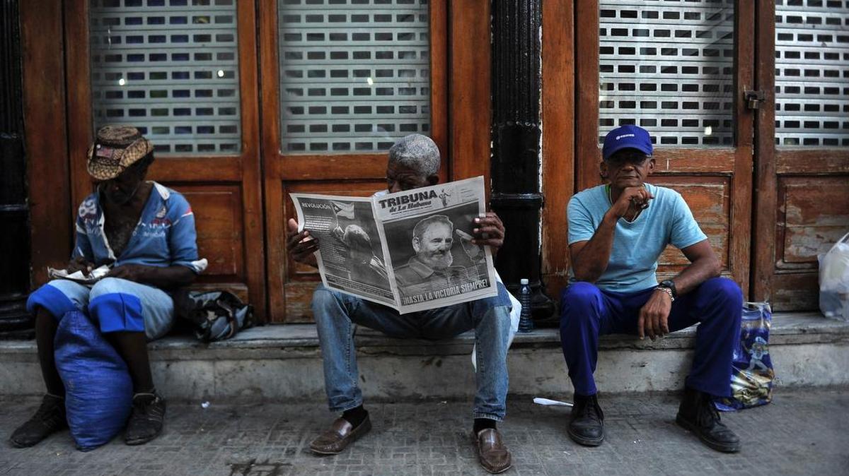 Un hombre lee un periódico en una calle de La Habana, el 27 de noviembre de 2016, dos días después de la muerte del líder cubano Fidel Castro.