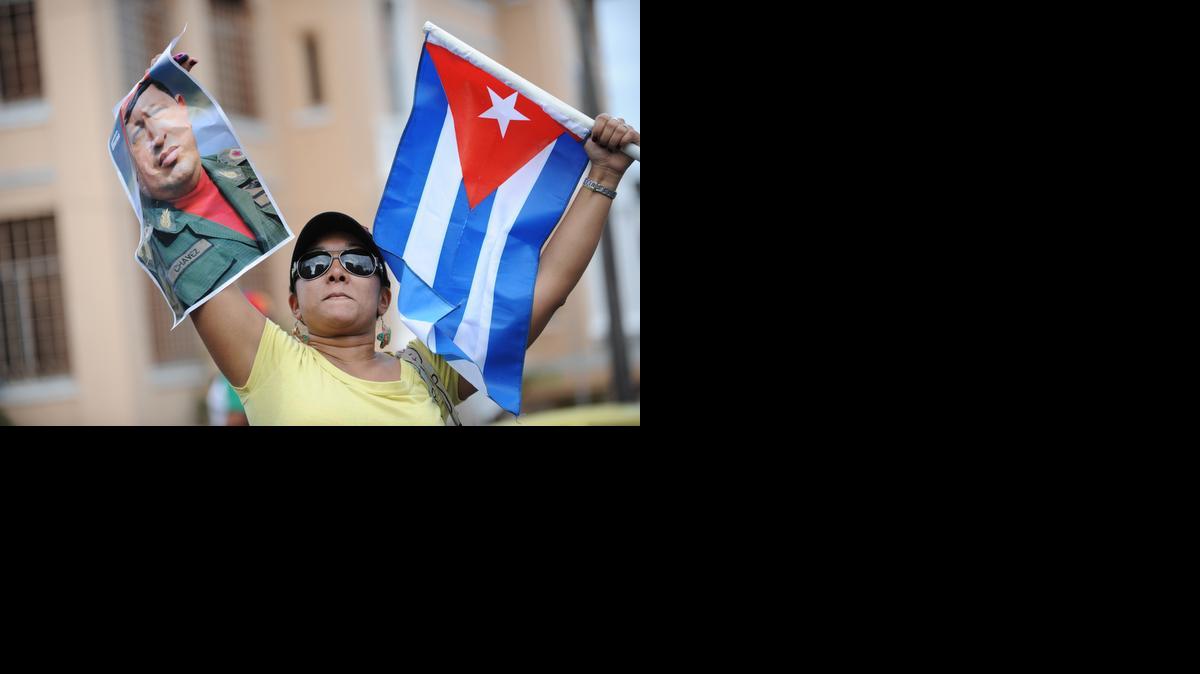 
Una mujer sostiene una foto del fallecido presidente venezolano Hugo Chávez y una bandera de Cuba el jueves, en Ciudad de Panamá. 

