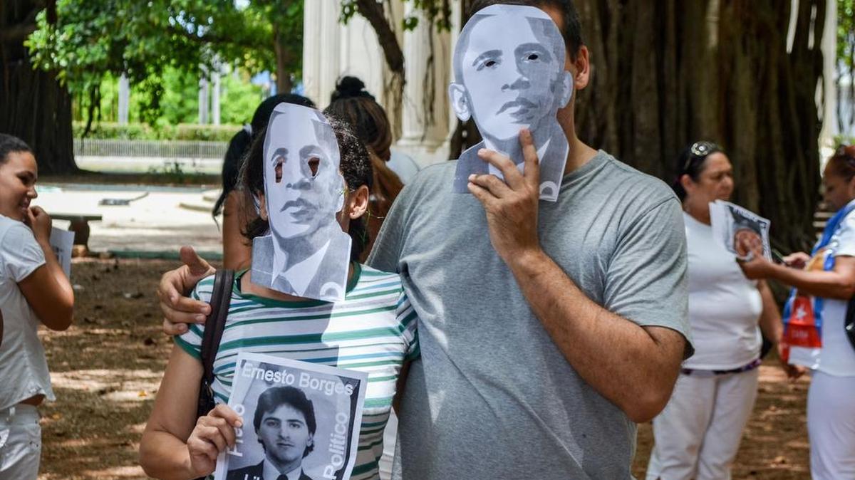 
Dos disidentes cubanos usan máscaras del presidente Barack Obama, durante una protesta contra la apertura de la embajada de EEUU, el domingo 9 de agosto, en La Habana. 
