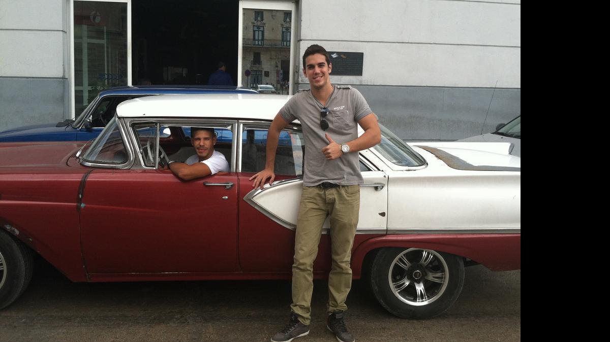
Mario Otero junto a un auto clásico americano conducido por su amigo Camilo Rodriguez en La Haban. Otero, de 25 años, wtrabaja como camarero en uno de los mejores restaurantes de la capital cubana y su amigo traslada turistas extranjeros.
