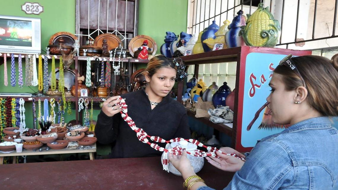 Una trabajadora vende artículos de santería en un negocio privado en La Habana.