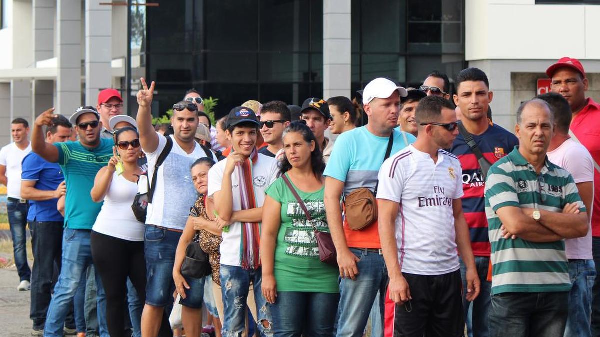 Decenas de cubanos hacen fila este 10 de febrero de 2016, en la ciudad de David, capital de la provincia occidental panameña de Chiriquí, para comprar el boleto de avión, por 523,50 dólares cada uno, para viajar a México.