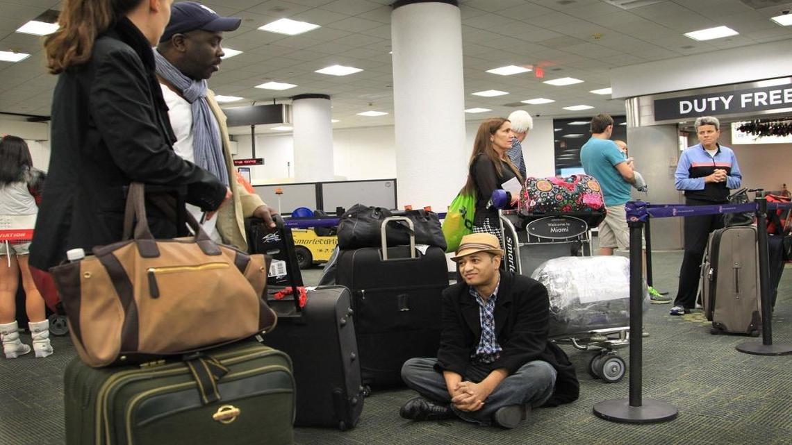 Decenas de personas esperan en el aereopuerto internacional de Miami para viajar a Cuba.