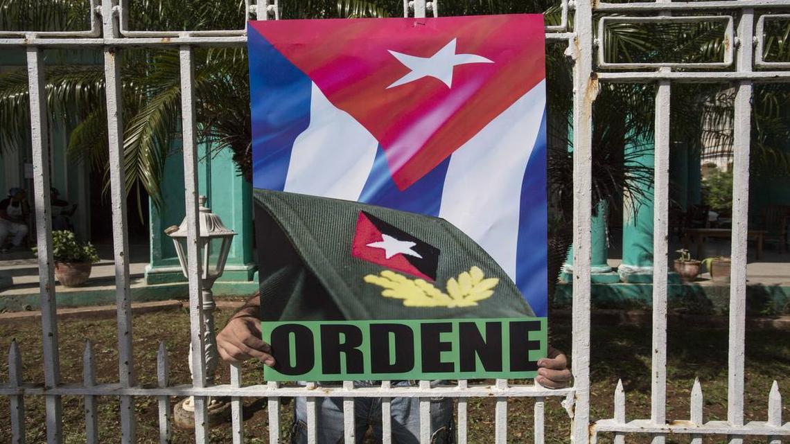 Un joven coloca el lunes un poster afuera de las instalaciones de la federación de estudiantes universitarios en La Habana.