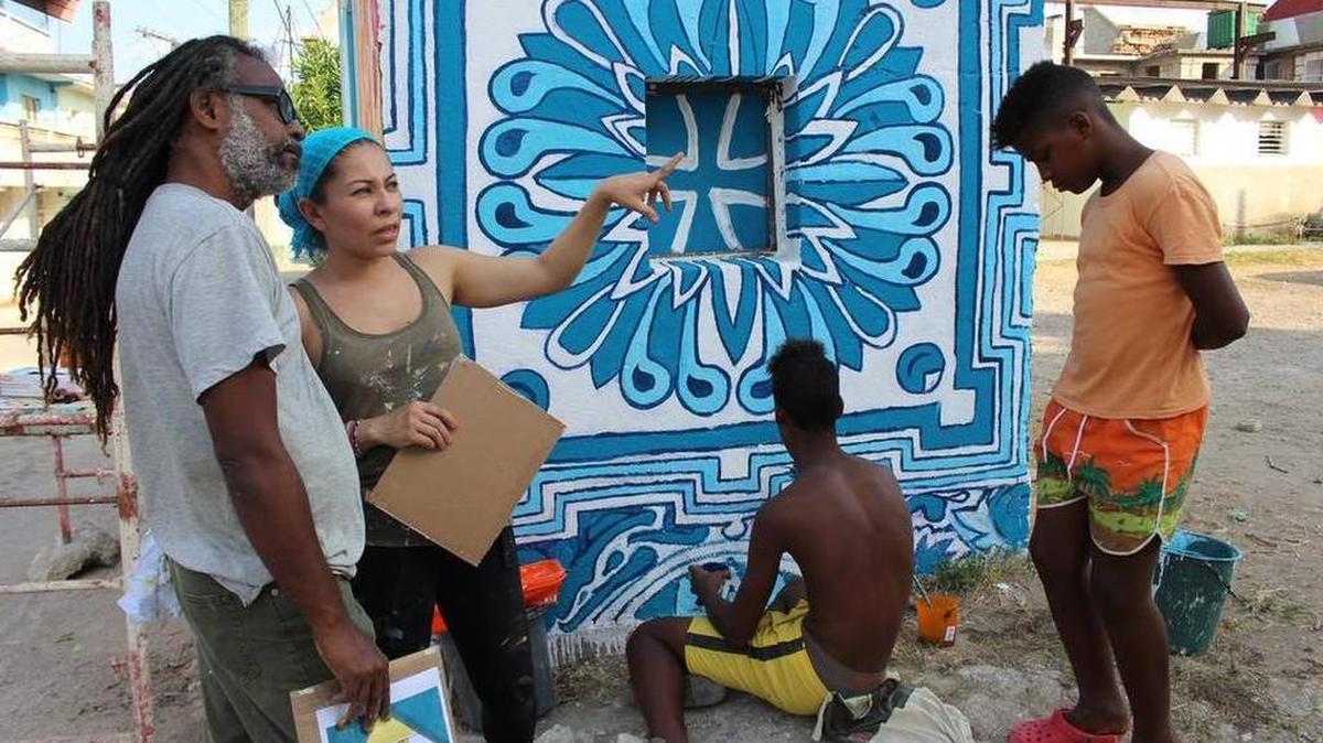 La muralista estadounidense Michelle Angela Ortiz, trabaja en un mural en Regla, en La Habana, junto a artistas locales y miembros de esa comunidad.