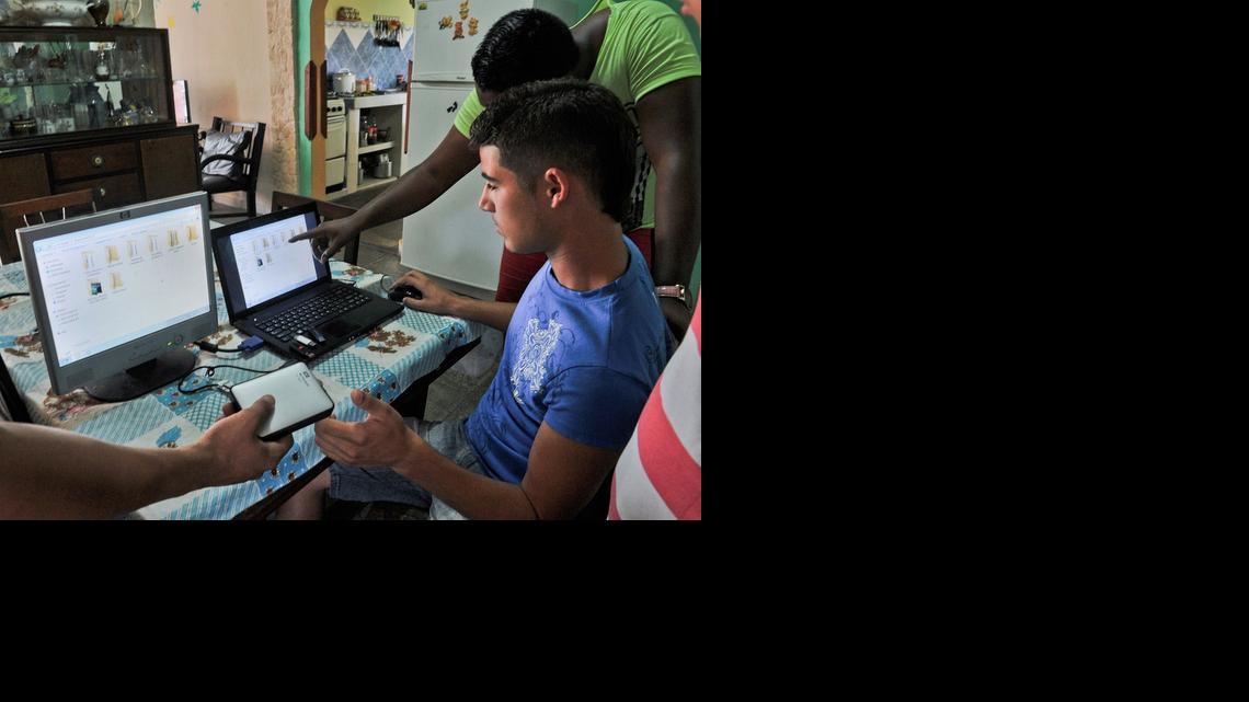 
Jóvenes preparan discos portátiles y unidades USB con películas, series de televisión, noticias y otra información, en abril del 2014 en La Habana. Solo el 3.4% de la población tiene conexiones privadas de internet.
