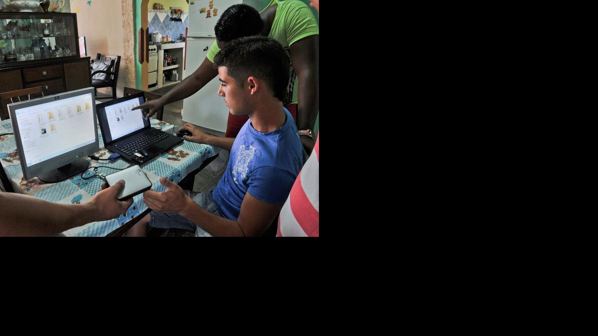 
Jóvenes preparan discos portátiles y unidades USB con películas, series de televisión, noticias y otra información, en abril del 2014 en La Habana. Solo el 3.4% de la población tiene conexiones privadas de internet.
