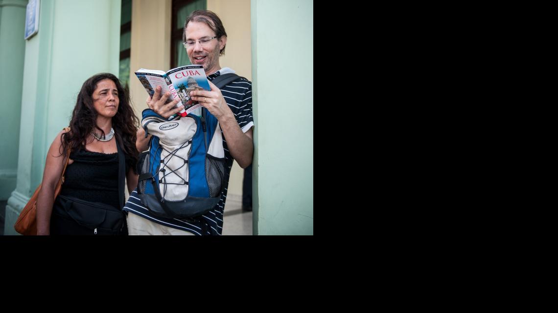 
Turistas de Estados Unidos leen una guía de Cuba, en las calles de La Habana, el 6 de abril de 2015. 
