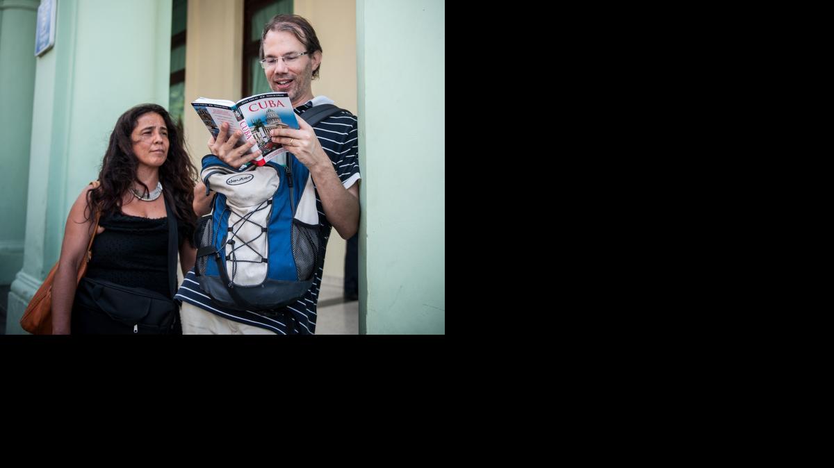 
Turistas de Estados Unidos leen una guía de Cuba, en las calles de La Habana, el 6 de abril de 2015. 
