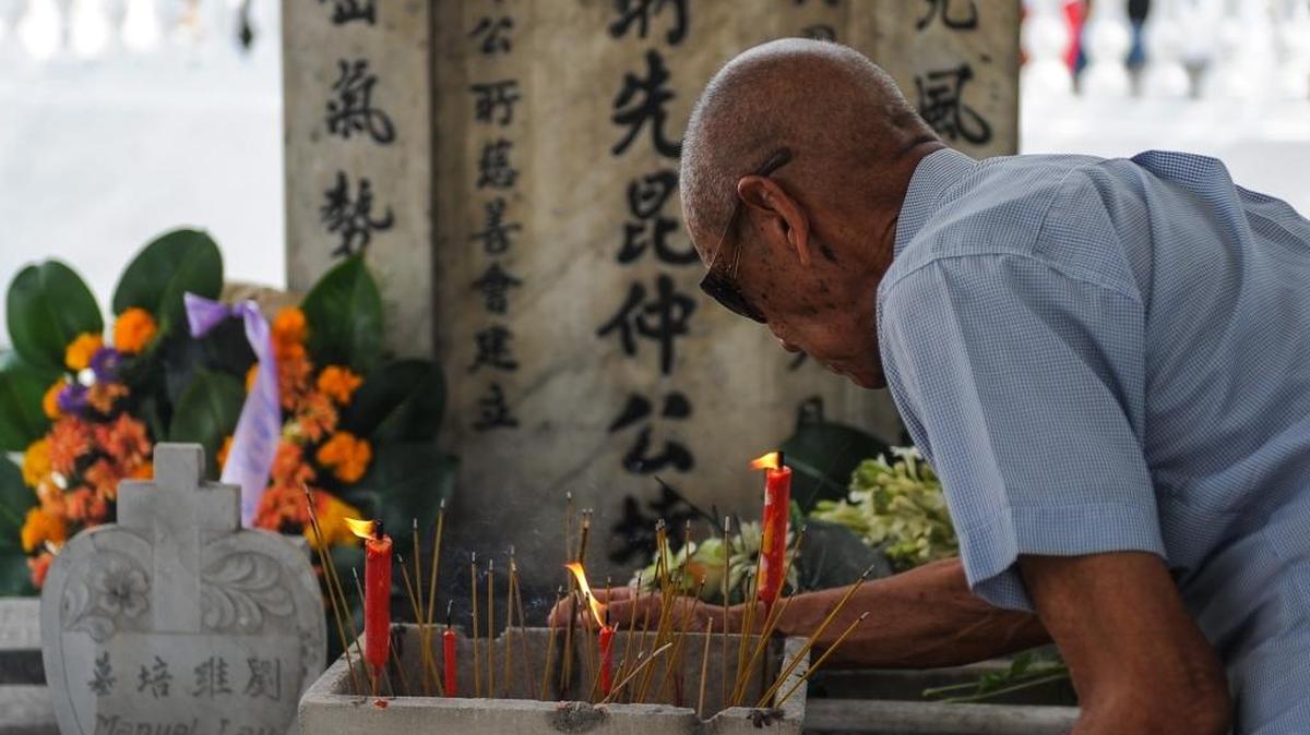Un descendiente chino visita la tumba de un familiar en el cementerio chino en La Habana.