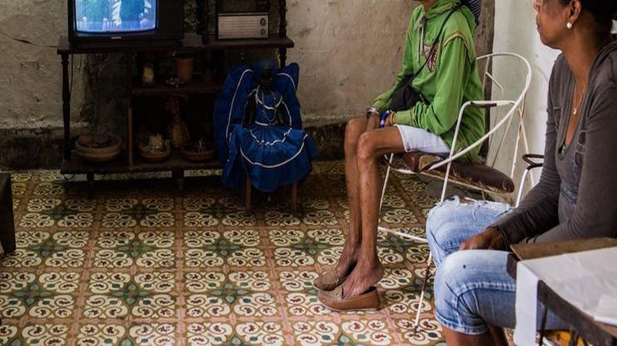 Anisia Cuesta Ordaz, de 46 años (der), Irma Ostia La Cruz, de 58 años (en el medio) y algunos de sus vecinos miran en la televisión el momento en que el presidente Barack Obama era recibido en La Habana por Raúl Castro el 21 de marzo del 2016.