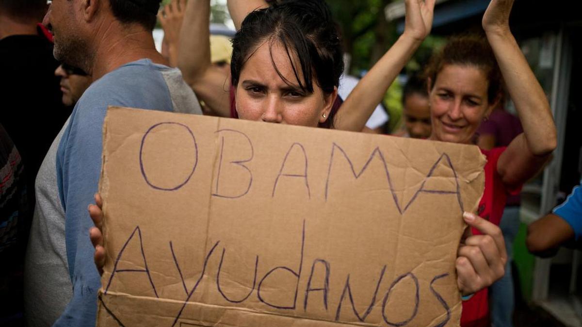Una cubana sostiene un cartel en un campamento para refugiados en la frontera de Costa Rica y Nicaragua.