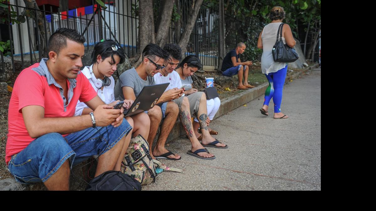 
Cubanos aprovechan la oportunidad de conexión a una red Wi-Fi en una de las zonas habilitadas por el gobierno de la isla en La Habana.
