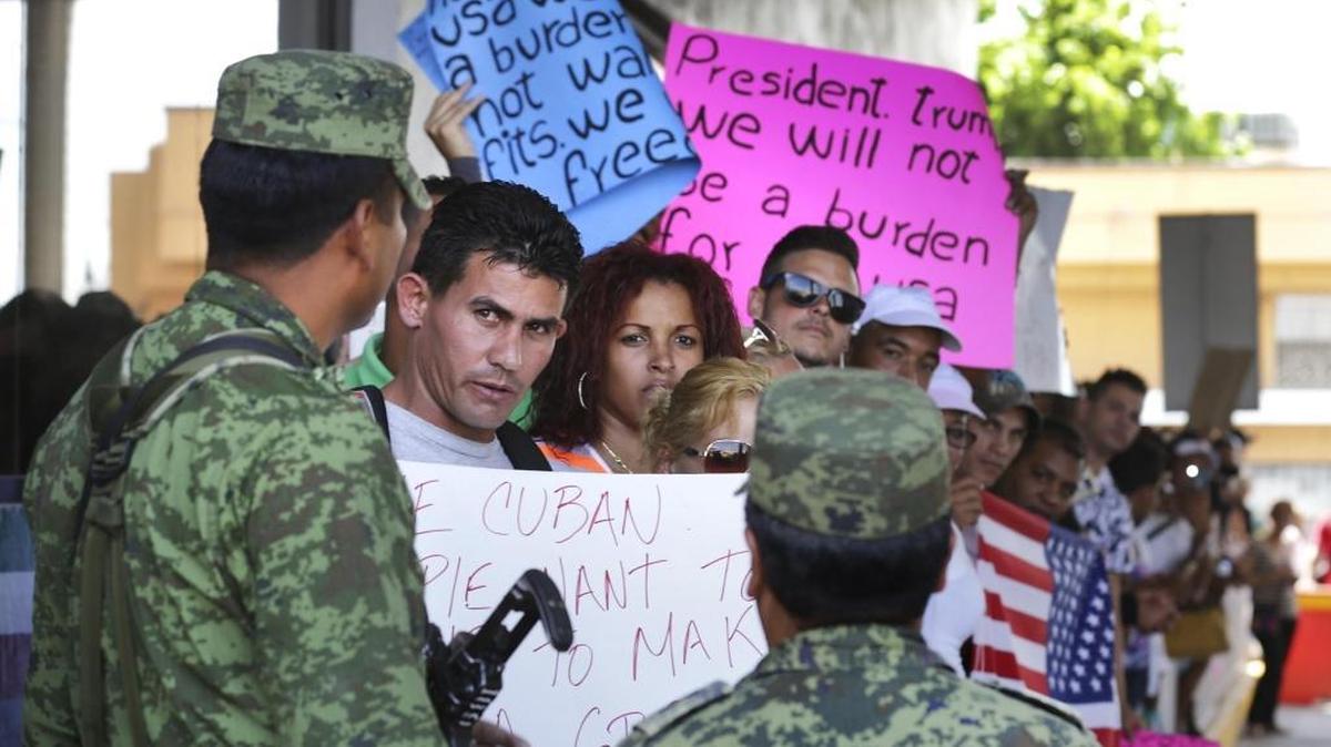 El migrante cubano Reinier Aguila Esquivel conversa con un soldado mexicano mientras él y otros cubanos varados en Nuevo Laredo intentan pasar al puente internacional luego de un mitin y una marcha desde Plaza Juárez hasta el Puente Internacional, el sábado, 8 de abril del 2017.