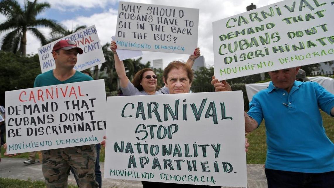 Víctor García (izq), María Hernández (atrás) y Miriam Domínguez (centro) participaron de la protesta de exiliados cubanos frente a las oficinas de Carnival en Doral.