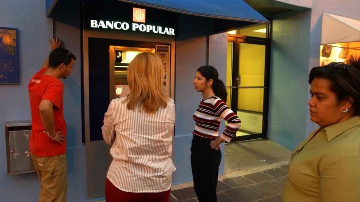 Personas esperan en linea en un cajero automático del Banco Popular en San Juan, Puerto Rico.