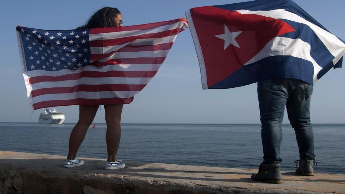 Yaney Cajigal y Dalwin Valdés, con las banderas de Estados Unidos y Cuba, esperan la llegada de un crucero de Carnival en La Habana el 2 de mayo del 2016.