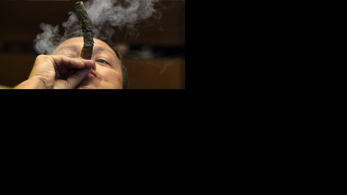 
Un hombre fuma un habano durante una competencia para obtener la ceniza más larga como parte de las actividades del XVII Festival del Habano en La Habana (Cuba).
