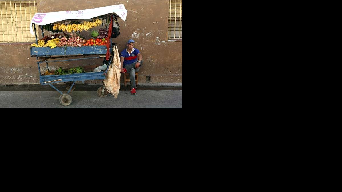 Foto de archivo. Un hombre vende frutas y verduras en una carretilla el viernes 19 de diciembre de 2014, por las calles de La Habana (Cuba).