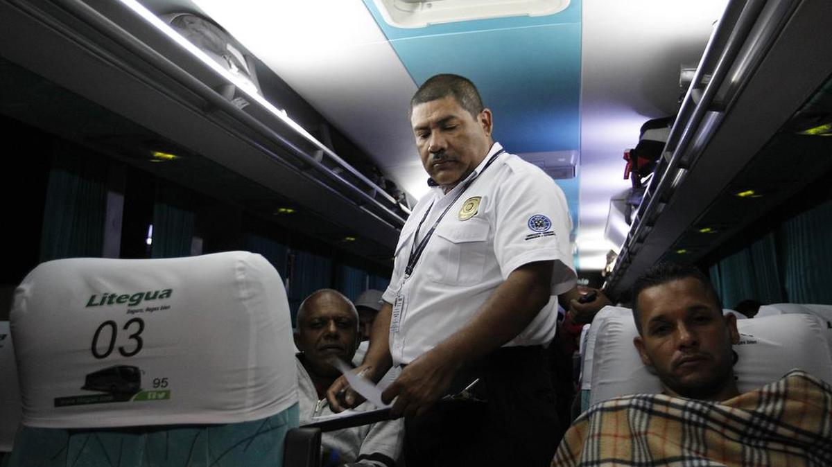 Un agente de inmigración revisa los documentos de migrantes cubanos en tránsito hacia Estados Unidos hoy, miércoles 13 de enero de 2016, en el paso por la frontera La Hachadura, entre Guatemala y El Salvador, a la altura de San Francisco Menéndez (El Salvador). 