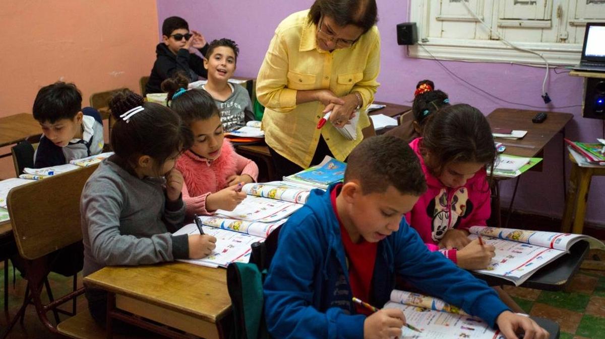 En esta foto del 5 de febrero de 2016, la profesora Graciela Lage ayuda a los estudiantes durante una lección de inglés en la Escuela Cubana de Idiomas Extranjeros en La Habana, Cuba.