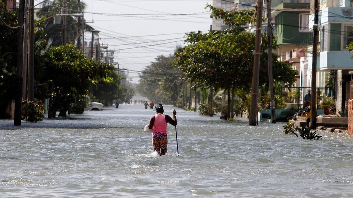 Una mujer camina por una calle inundada, el sábado, en La Habana, Cuba.