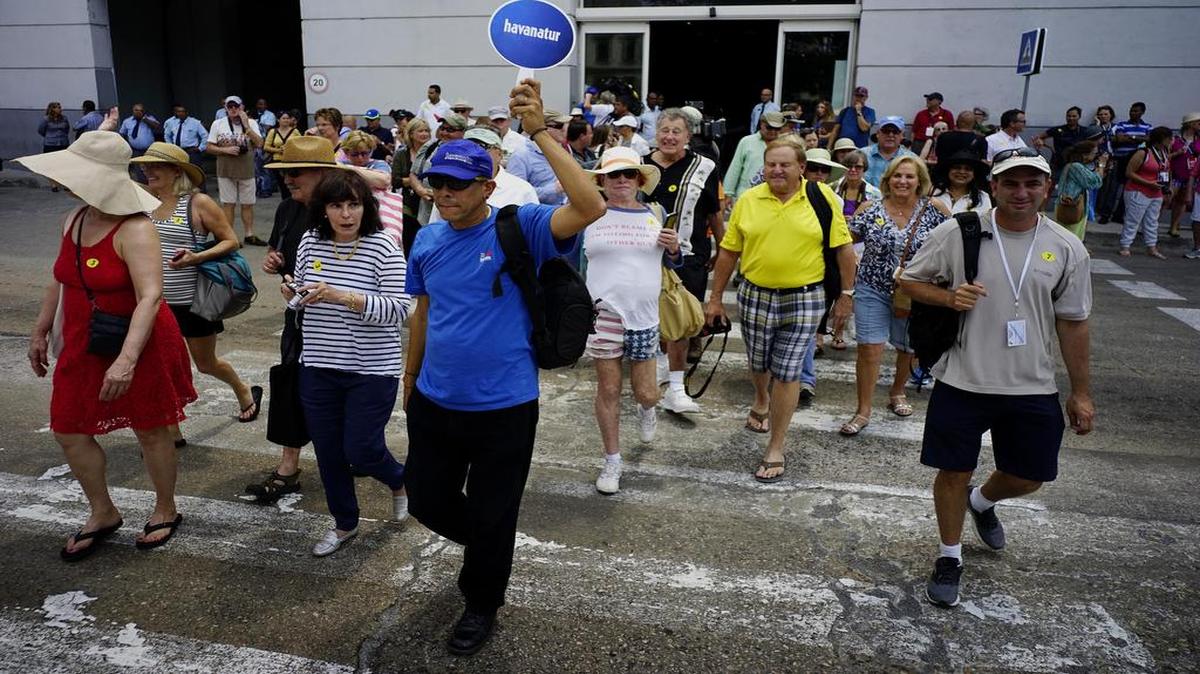 Algunos de los pasajeros del crucero Adonia de Carnival cruzan la calle tras salir de la terminal en La Habana.