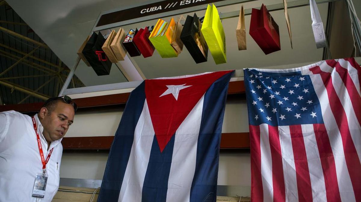 Las banderas de Cuba y EEUU cuelgan frente al stand de muestra de una compañía estadounidense en la Feria Comercial de La Habana.