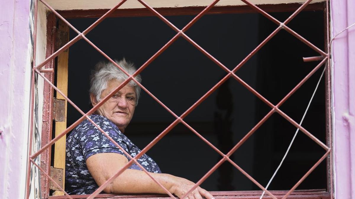 Una mujer de edad se sienta cerca de su ventana en un hogar de La Habana.
