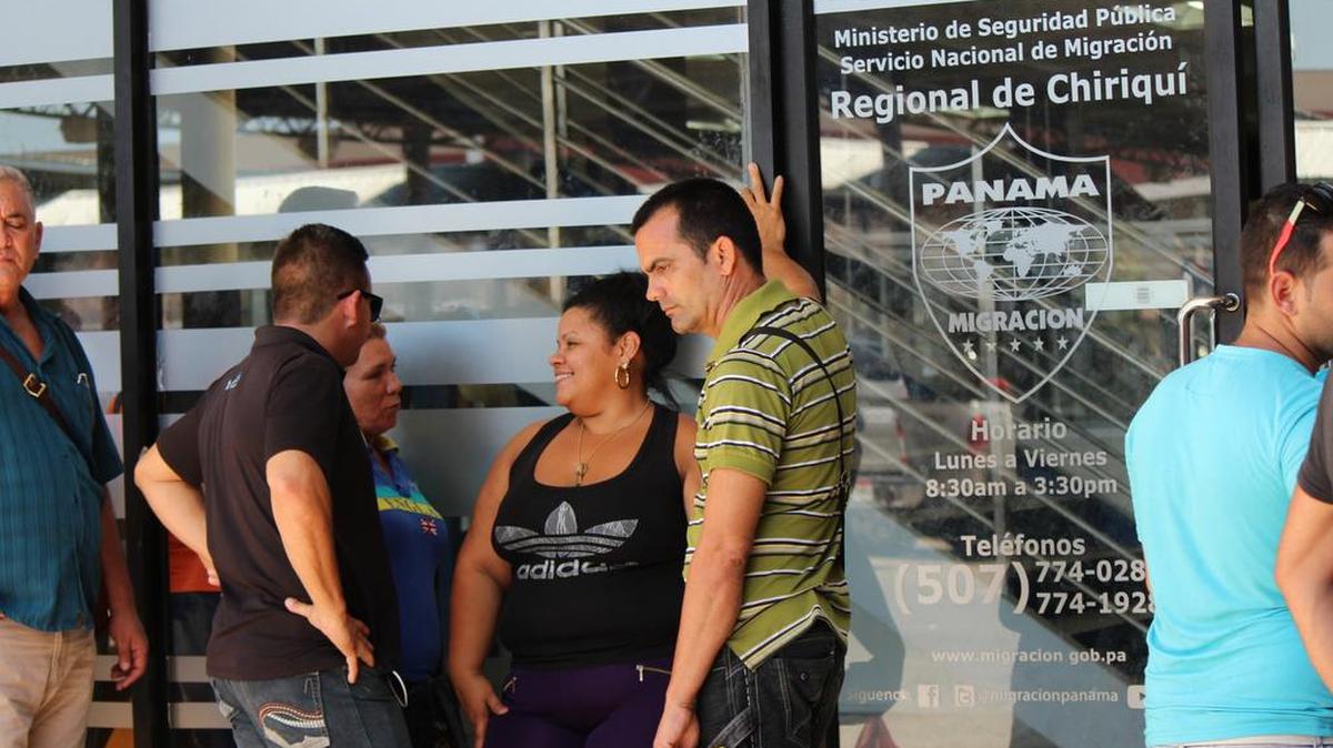 Migrantes cubanos esperan el domingo 21 de febrero de 2016, a las puertas de la oficina de Migración de David, para recibir en sus pasaportes un permiso migratorio para poder salir legalmente de Panamá hacia México, desde donde cruzarán a Estados Unidos.