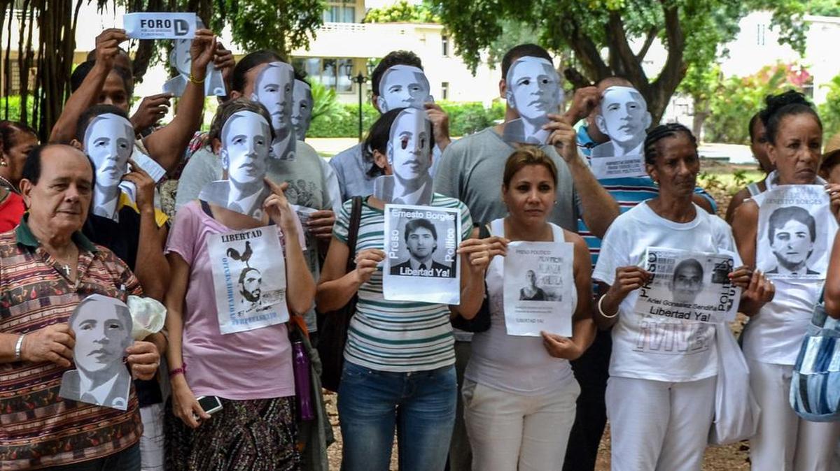 
Disidentes cubanos y Miembros de las Damas de Blanco sostienen Una bandera nacional cubana y fotos de Los Disidentes encarcelados, ya Que Protestan contra la reapertura de la embajada de Estados Unidos en la isla, En un parque de La Habana, el 9 de agosto de 2015 .
