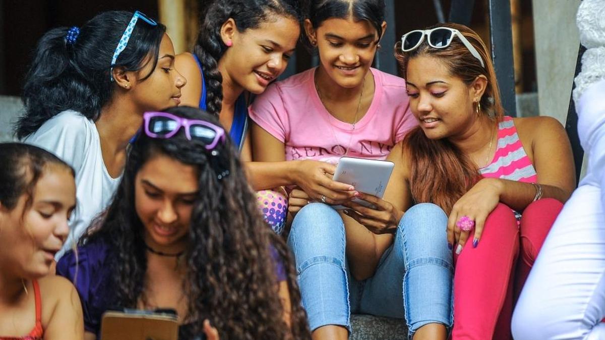 Jóvenes cubanas usan sus teléfonos en las calles de La Habana, tras el anuncio de 35 áreas abiertas de WiFi, en julio.