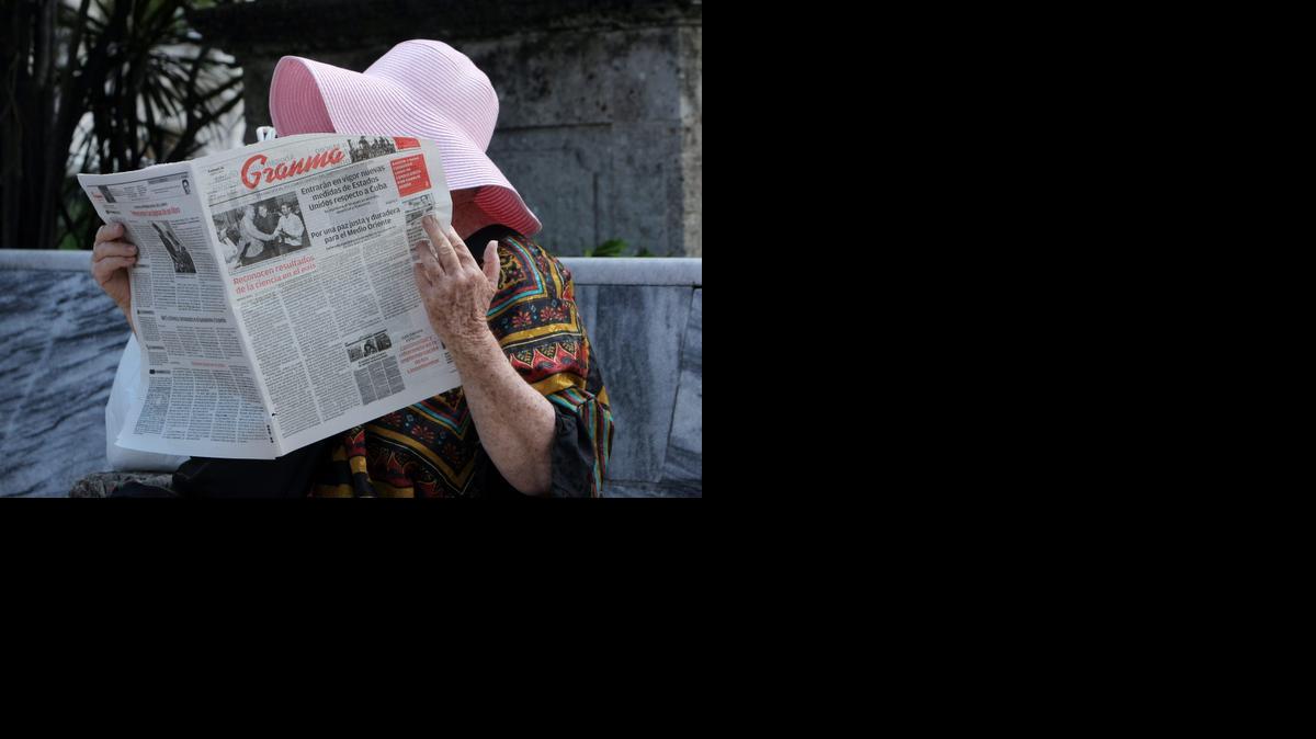 
Una mujer lee el periódico Granma, que abre información de la implementación de las nuevas medidas de Estados Unidos con respecto a Cuba, hoy, viernes 16 de enero de 2015, en La Habana (Cuba).