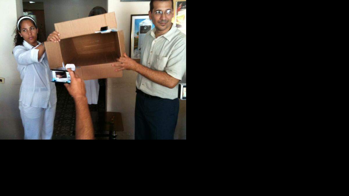 
El activista Antonio Rodiles y una miembro de las Damas de Blanco muestran la urna vacía antes de iniciarse la votación en La Habana. 

