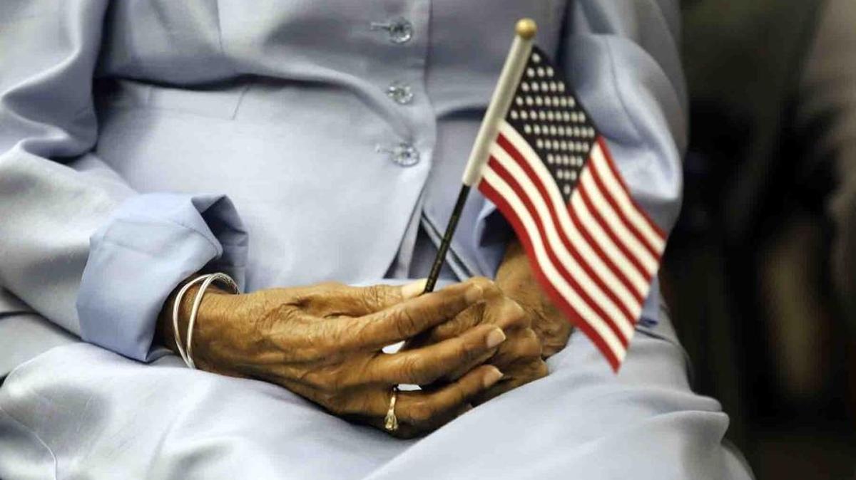 Una mujer sostiene una pequeña bandera de Estados Unidos durante una ceremonia de ciudadanía.