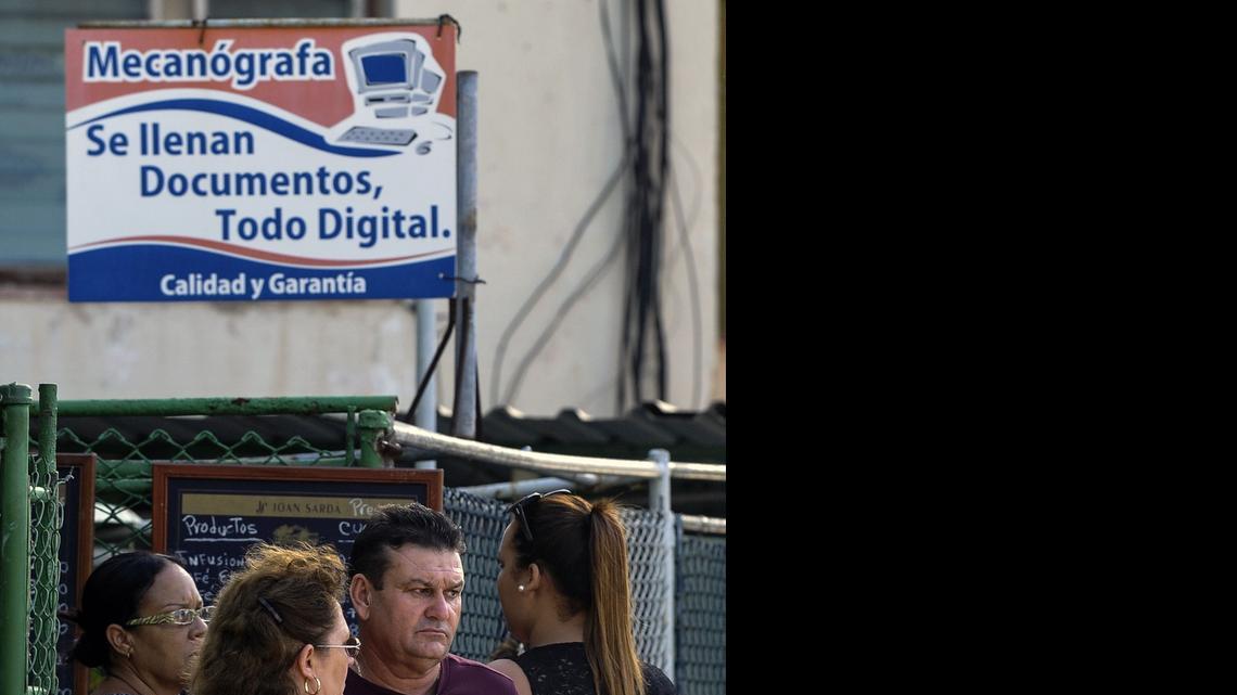 
Varias personas esperan para que les llenen planillas con las cuales solicitar una visa en la Sección de Intereses de Estados Unidos en La Habana. 
