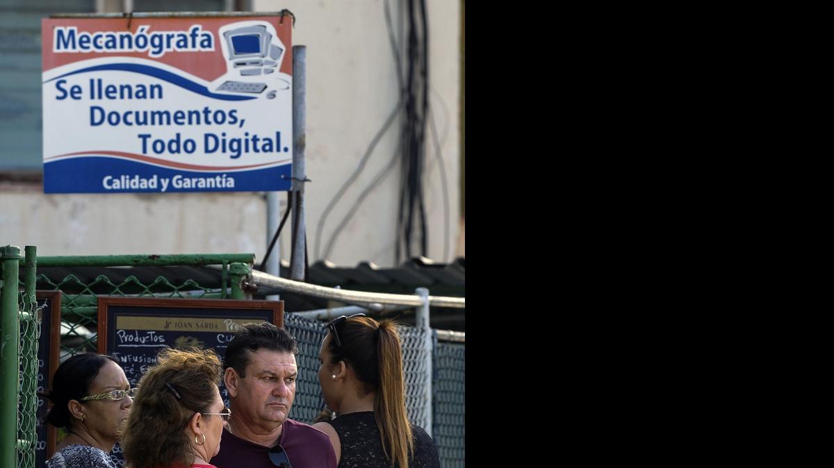 
Varias personas esperan para que les llenen planillas con las cuales solicitar una visa en la Sección de Intereses de Estados Unidos en La Habana. 
