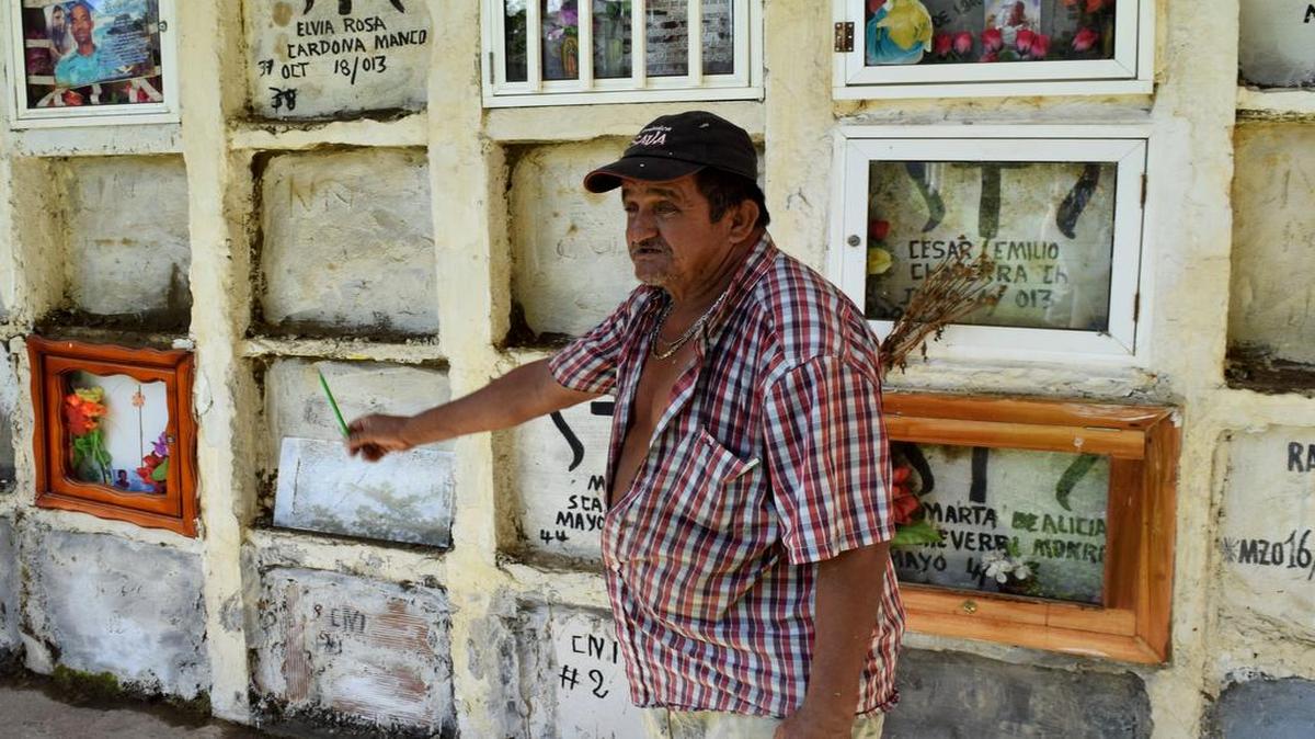 Ebelio Cortez muestra las tumbas de migrantes no identificados en el cementerio de Turbo, en Colombia.