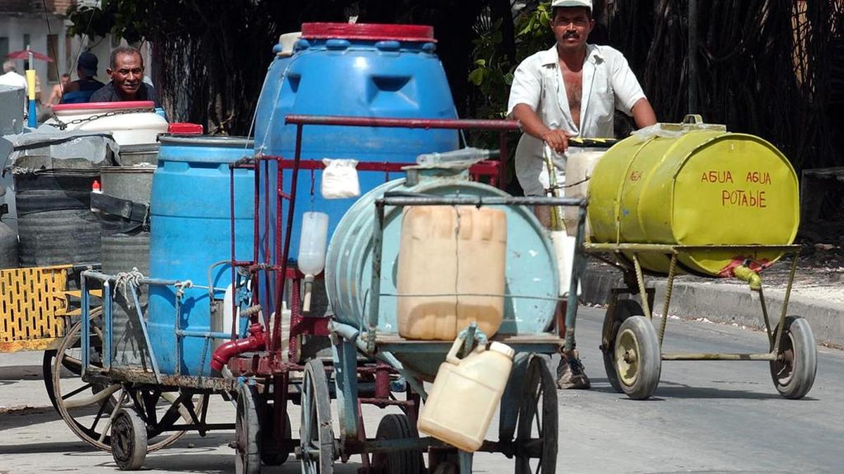 Un hombre llega en su bicicleta a un punto de agua en Holguín, Cuba. Foto de archivo.