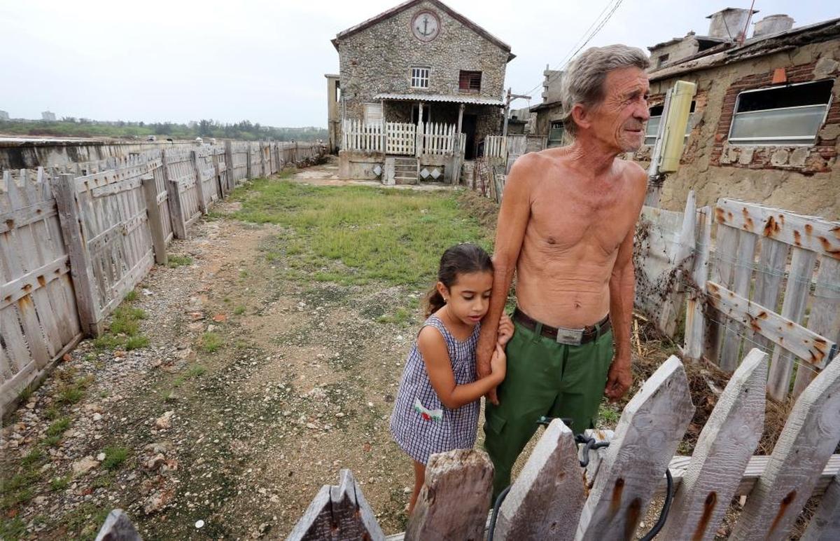 Dianik Abril Martínez Fraga, de 5 años, se aferra a su abuelo, José Fraga, frente a su casa costera en Cojímar. El huracán Irma dejó un agujero en el techo de su casa, que ya ha sido remendado con materiales que obtuvieron del estado.