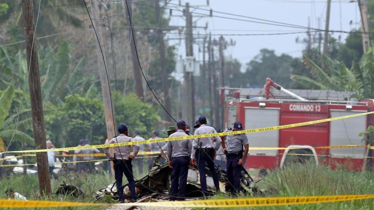 Policías y militares custodian los restos del avión Boeing-737 que se estrelló el viernes 18 de mayo de 2018, poco después de despegar del aeropuerto José Martí de La Habana (Cuba). Tres personas sobrevivieron al accidente aéreo ocurrido hoy al estrellarse un Boeing 737 de Cubana de Aviación que acababa de despegar del aeropuerto internacional de La Habana con destino a la provincia de Holguín (este de la isla), informaron hoy medios oficiales.
