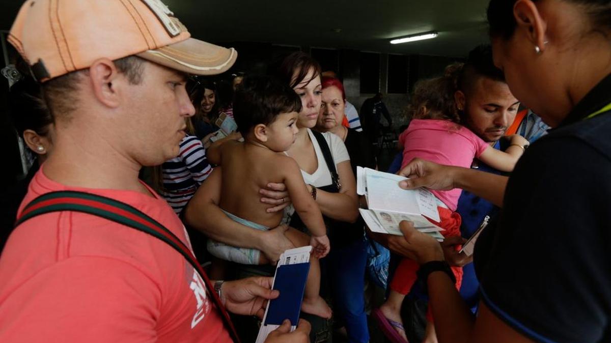 Un funcionario de Migración revisa los documentos a migrantes cubanos antes de abordar un vuelo fletado en Panamá, el 10 de mayo del 2016.